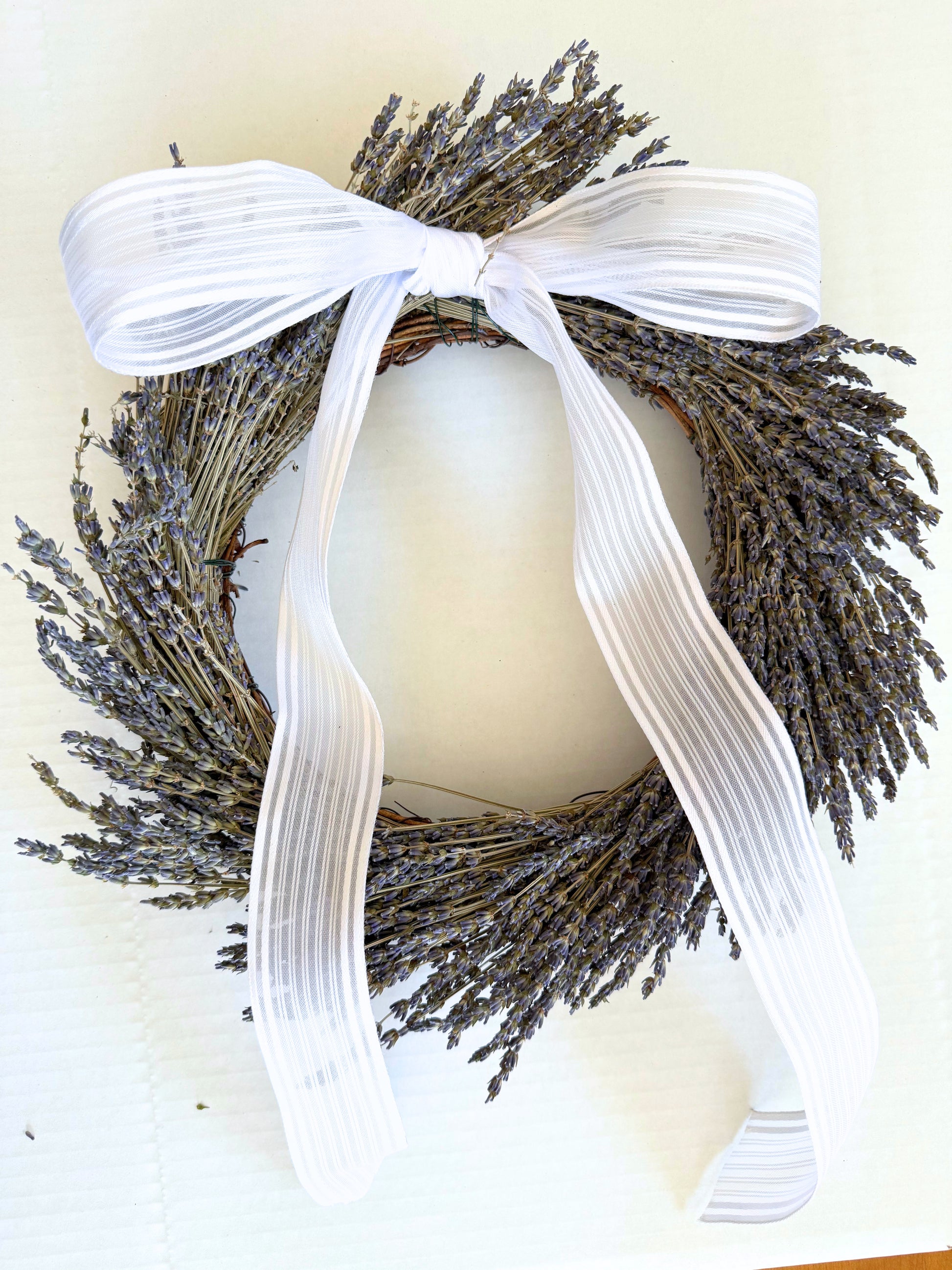 Round lavender wreath with wide striped white ribbon